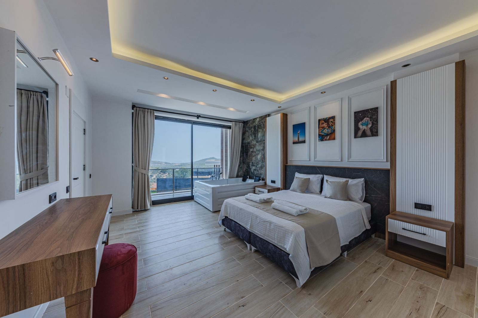 Modern room with a large bed and a balcony overlooking the water
