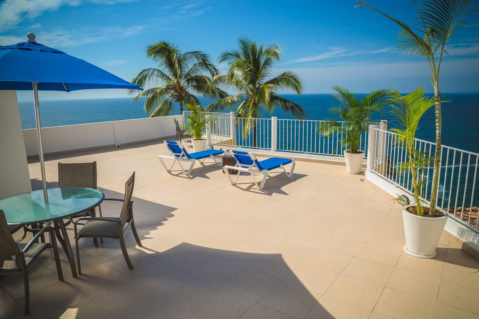 Private sun terrace with loungers and umbrellas overlooking the sea