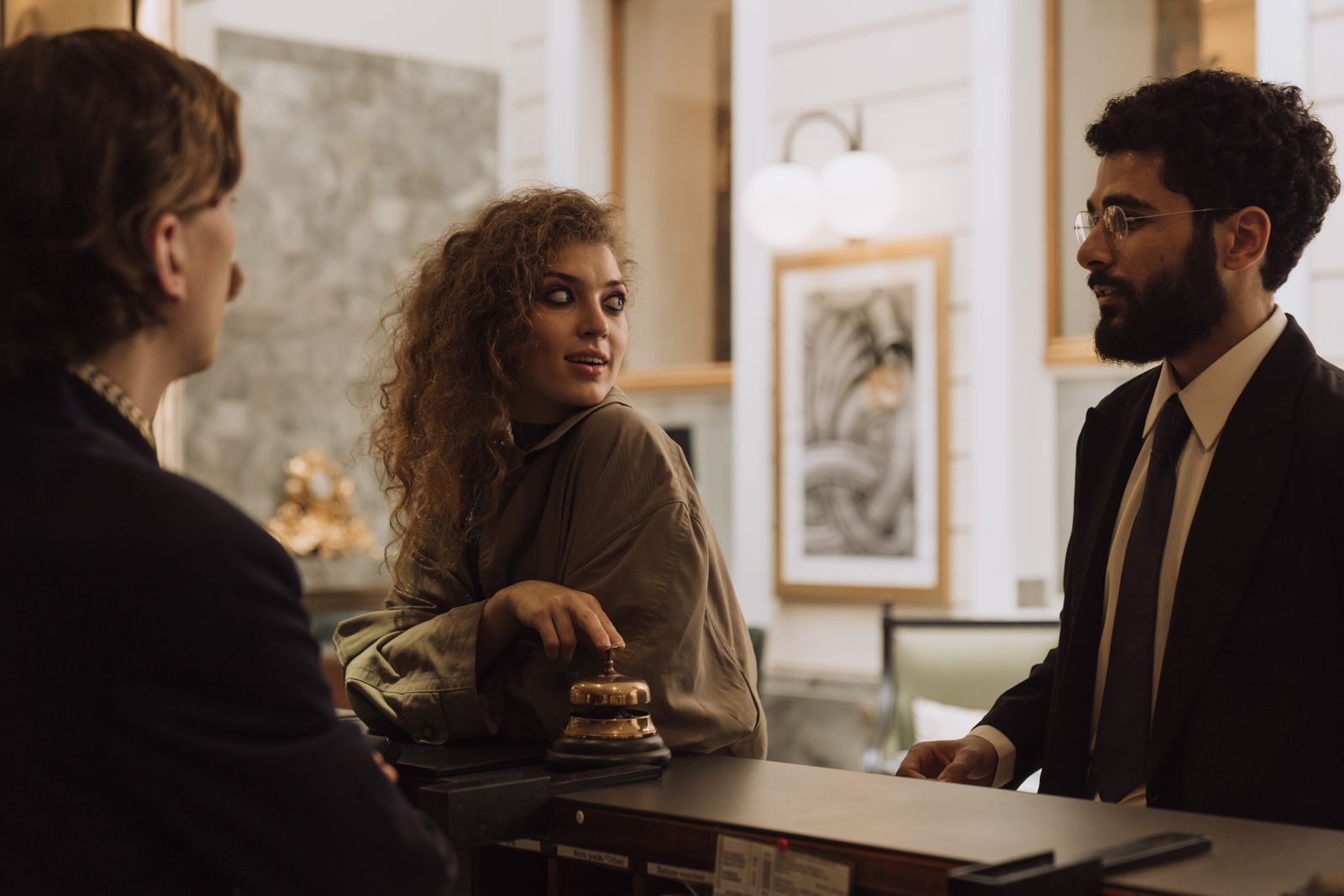 Guests talking with a staff member across a reception desk, as you would with the concierge on a cruise ship