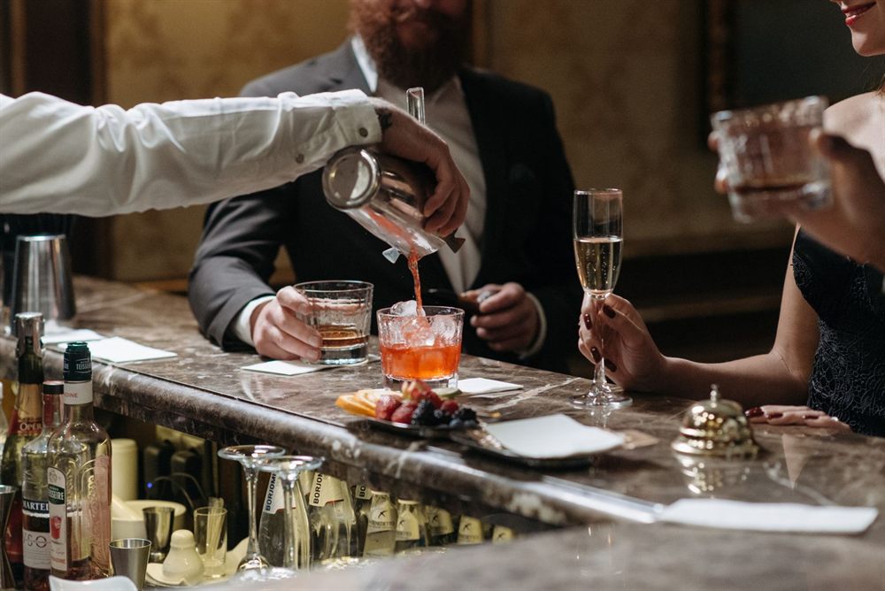 Bartender serving cocktails to guests in an upscale lounge bar