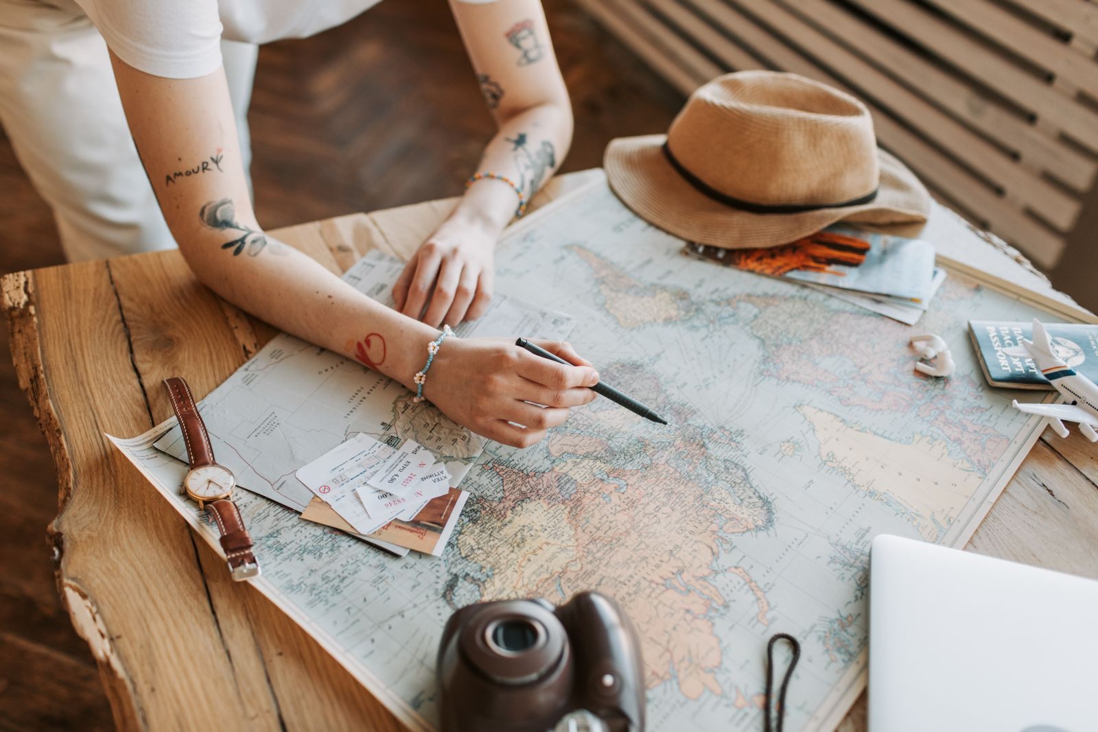 Traveler planning a trip with a world map, passport and notebook, much as a cruise concierge service does